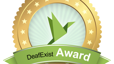 Der DeafExist Award. Eine Goldumrandung hält einen Origami Papiervogel der in die Luft steigt. 
