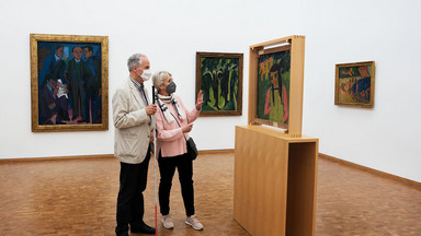 Eine Frau und ein Mann stehen vor einem Bild im Museum