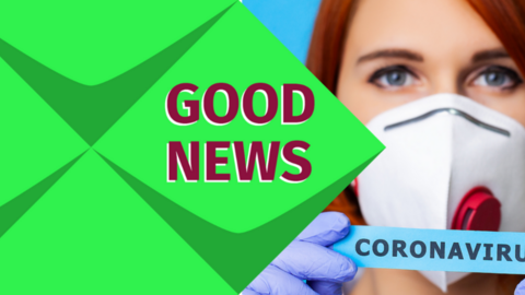 Links steht: Good News. Eine Frau mit einer Maske. Sie trägt ein Schild zum Thema Coronavirus. 