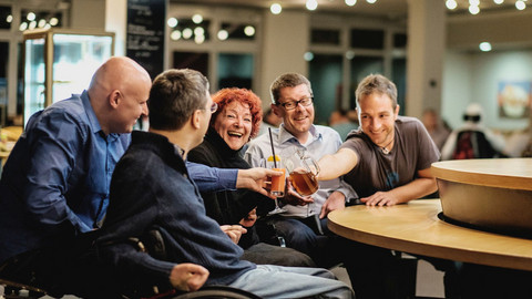 Mehrere Personen sitzen in fröhlicher Atmosphäre um einen Tisch. Foto: Andi Weiland I Gesellschaftsbilder.de