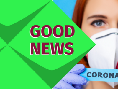 Links steht: Good News. Eine Frau mit einer Maske. Sie trägt ein Schild zum Thema Coronavirus. 