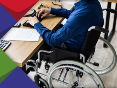 Eine Person im Rollstuhl am Schreibtisch: ein Symbolbild für einen Menschen, der an seinem Schreibtisch arbeitet. Er sitzt übrigens im Rollstuhl. Das Bild soll symblisch zeigen: Menschen mit Behinderungen wollen auf dem ersten Arbeitsmarkt arbeiten.