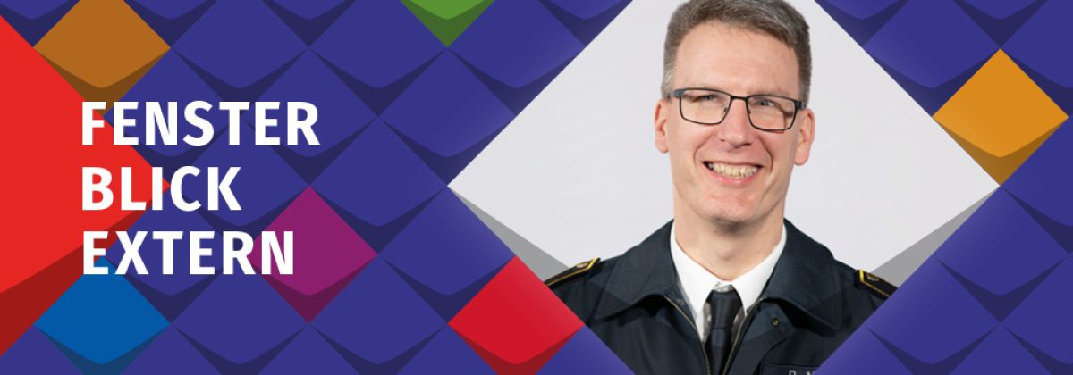 Ein Foto von Daniel Meyer, ein Manm mit Brille und kurzem dunkelblond-grauem Haar, der eine Feuerwehr-Uniform, ein weißes Hemd und eine dunkle Krawatte trägt. Er lächelt. Drumherum befinden sich Schmuckelemente der KSL.NRW