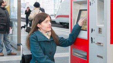 Urheber: Wolfgang Bellwinkel / DGUV Frau im Rollstuhl am Fahrkartenautomat