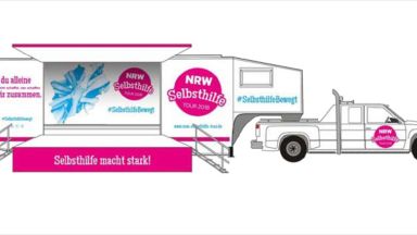 Selbsthilfetruck NRW Bild des Selbsthilfetrucks NRW von der Seite. Es ist ein Sattelzug aus einem Pickup rechts mit aufgeklappten Sattelauflieger.
