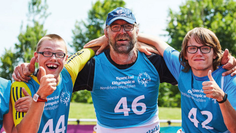 Gruppe von Sportlern posiert fröhlich für ein Gruppenbild