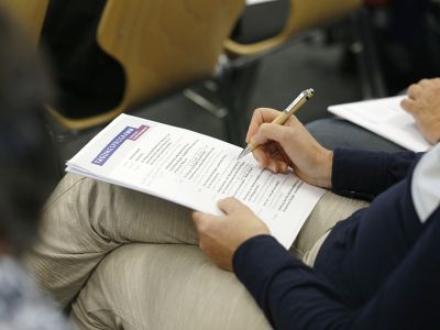 Tagungsprogramm der Fachtagung in den Händen einer Teilnehmerin