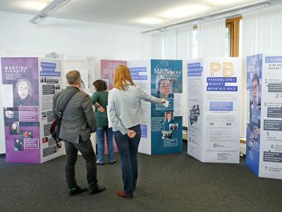 Blick auf die Wanderausstellung mit zwei Personen im Vordergrund