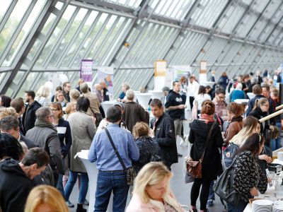 Arcade des Wissenschaftsparks während des Marktplatzes zur Kommunikation und Vernetzung. Viele Personen an Ständen und im Gespräch.