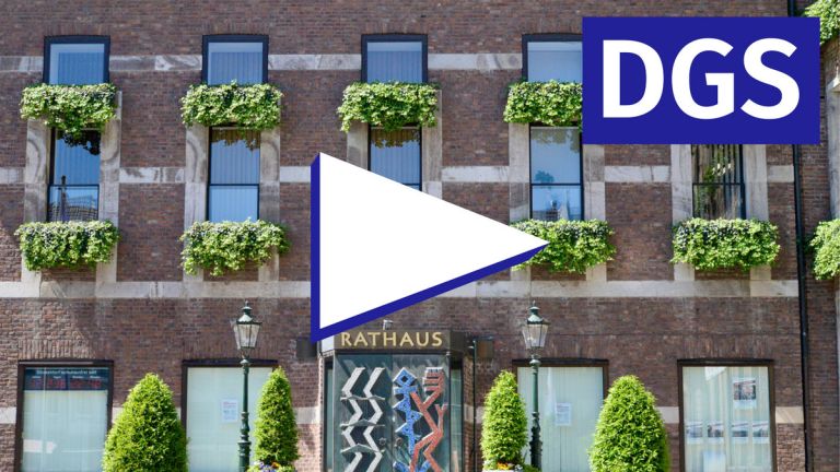 Play-Button vor einer Fassade eines Rathauses